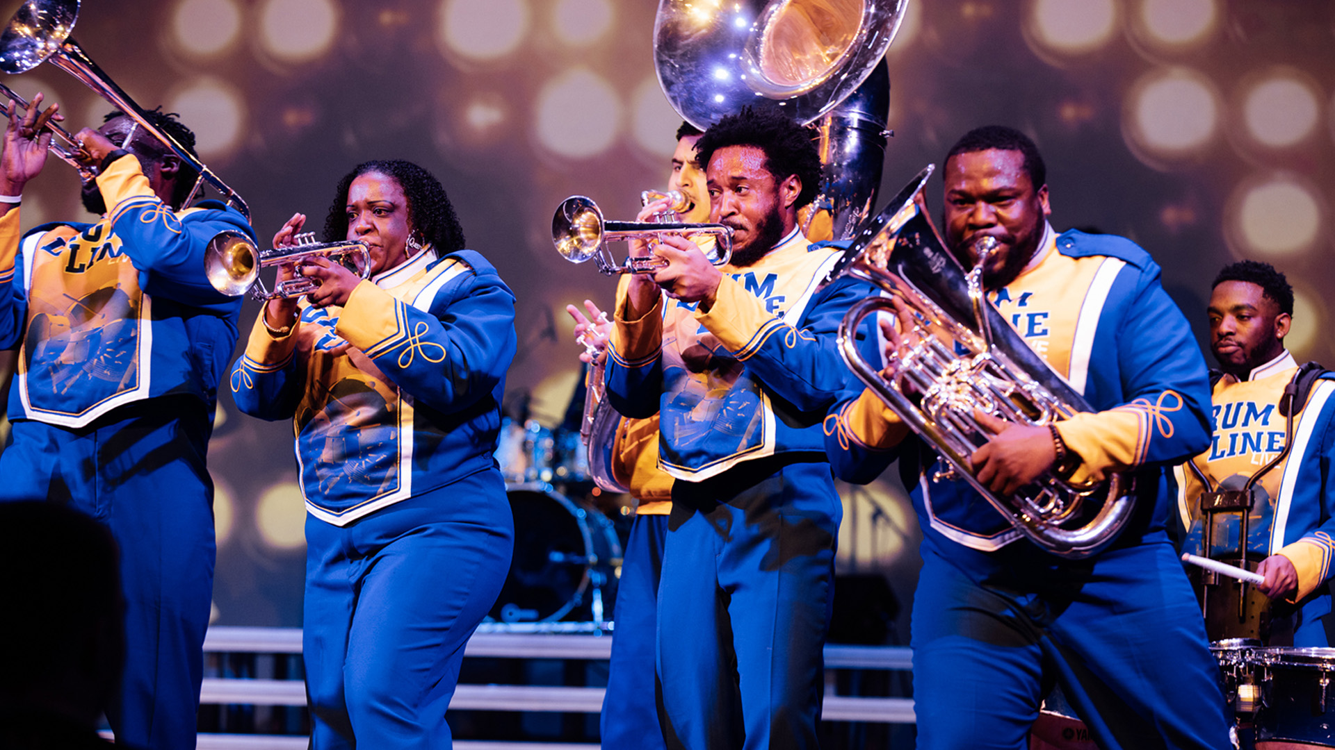 A group of people in band uniforms playing instruments 