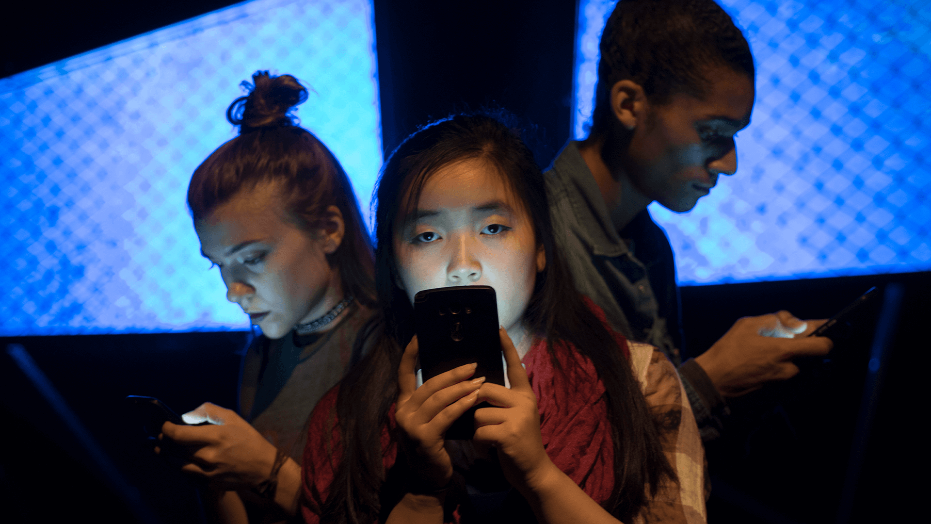 Three teens on their phones