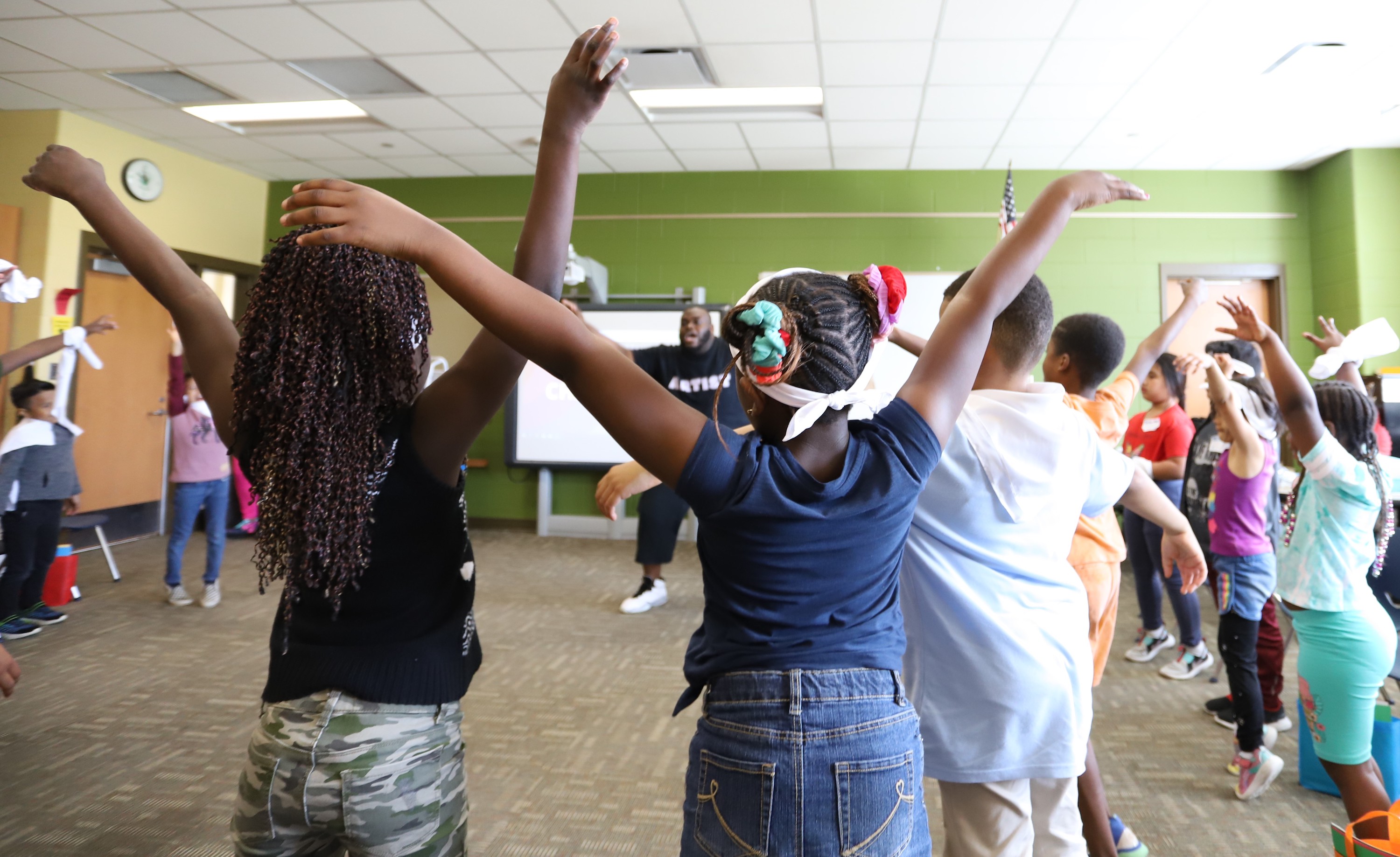 Teaching Artist workin with kids who appear to be dancing