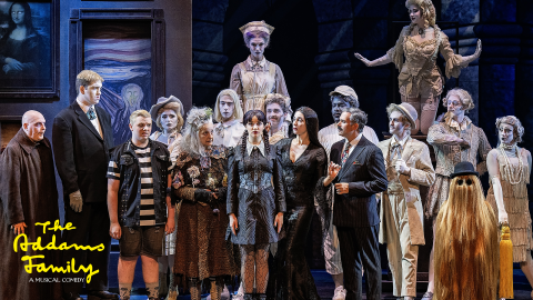 A group of monster characters all looking at one character in the middle dressed in suits and costumes