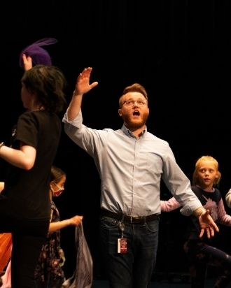 The actor Joseph sings as he's surrounded by youth choir members.