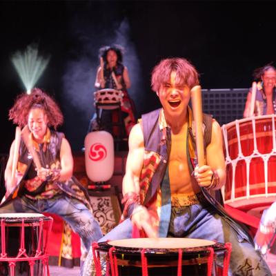 An excited group banding on big drums 